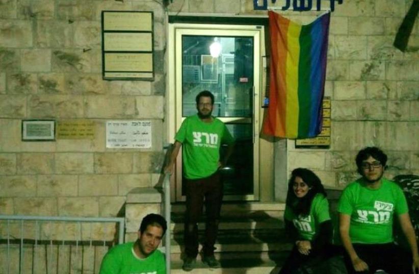 Meretz activists hoist the LGBT Pride flag outside the office of Chief Jerusalem Rabbi Shlomo Amar after he made disparaging remarks about the community (photo credit: MERETZ)