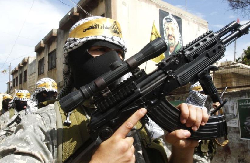Palestinian Fatah members carry their weapons as they take part in a Nakba parade, at Ain al-Hilweh Palestinian refugee camp near the port-city of Sidon. (photo credit: REUTERS)