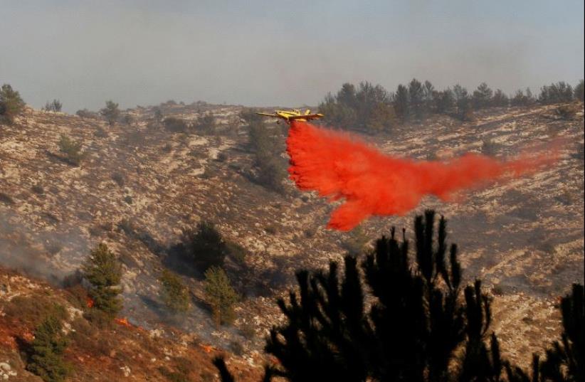 A firefighting plane drops fire retardant during a wildfire, near the communal settlement of Nataf, close to Jerusalem November 23, 2016. (photo credit: REUTERS)