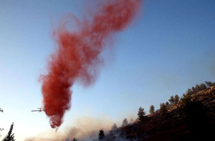 A firefighting plane drops fire retardant during a wildfire, near the communal settlement of Nataf, close to Jerusalem November 23, 2016.  (photo credit: REUTERS)