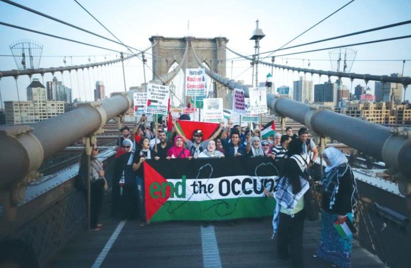 DEMONSTRATORS SHOUT pro-Palestinian slogans as they march across the Brooklyn Bridge during a pro-Palestinian rally in New York City in 2014. (photo credit: EDUARDO MUNOZ / REUTERS)