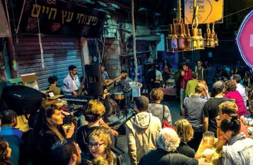 PATRONS CONVERGE on the Beer Bazaar in the Mahaneh Yehuda market, also known as the shuk, in downtown Jerusalem (photo credit: TOVA MOSKOWITZ)