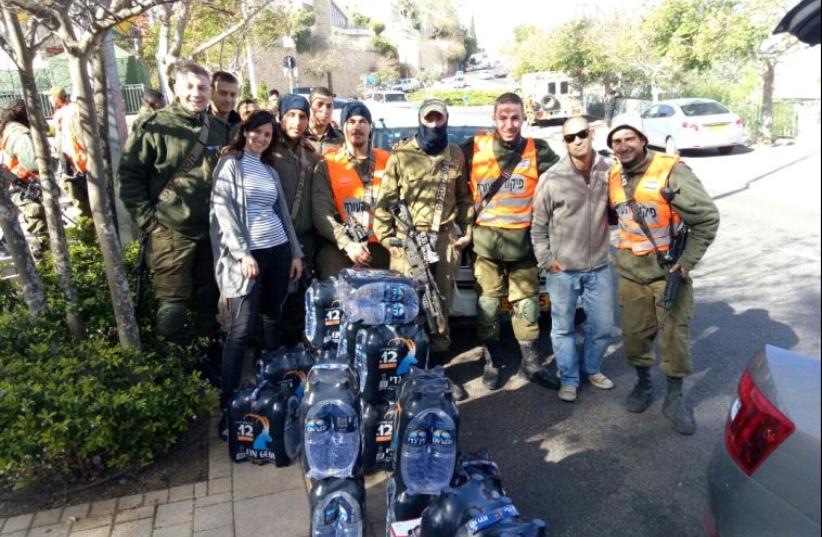 Volunteers at the Leo Beck Community Center in Haifa bring water bottles to security forces and firefighters battling the fires. (photo credit: LEO BECK COMMUNITY CENTER IN HAIFA/ASSOCIATION OF COMMUNITY CENTERS IN ISRAEL)