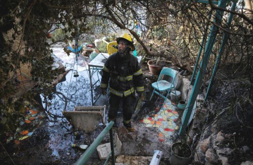 A firefighter surveys the damage from a fire in Haifa (photo credit: REUTERS)