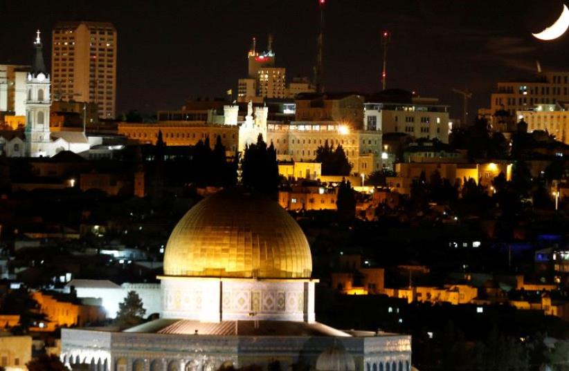 The moon is seen from the Dome of the Rock on the Temple Mount compound. (photo credit: REUTERS)