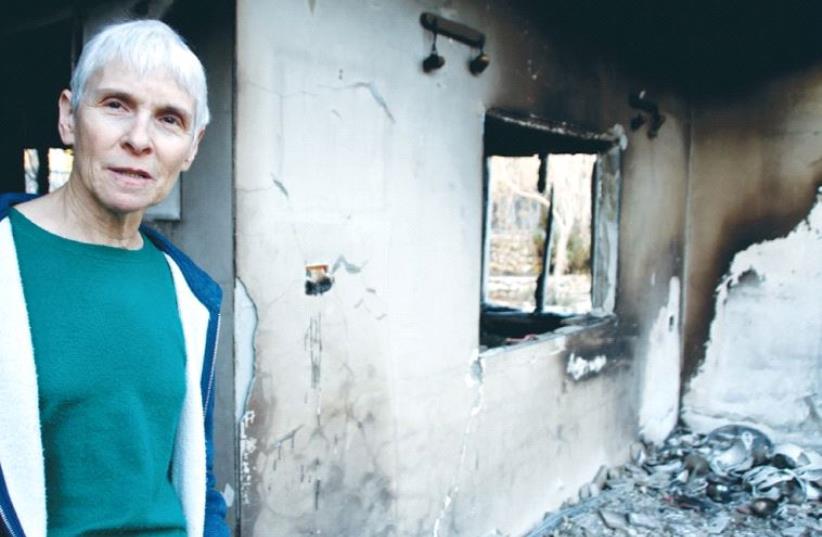 DR. AMY ROSENBLUH stands in the doorway of her fire-gutted home in the settlement of Halamish yesterday.  (photo credit: TOVAH LAZAROFF)