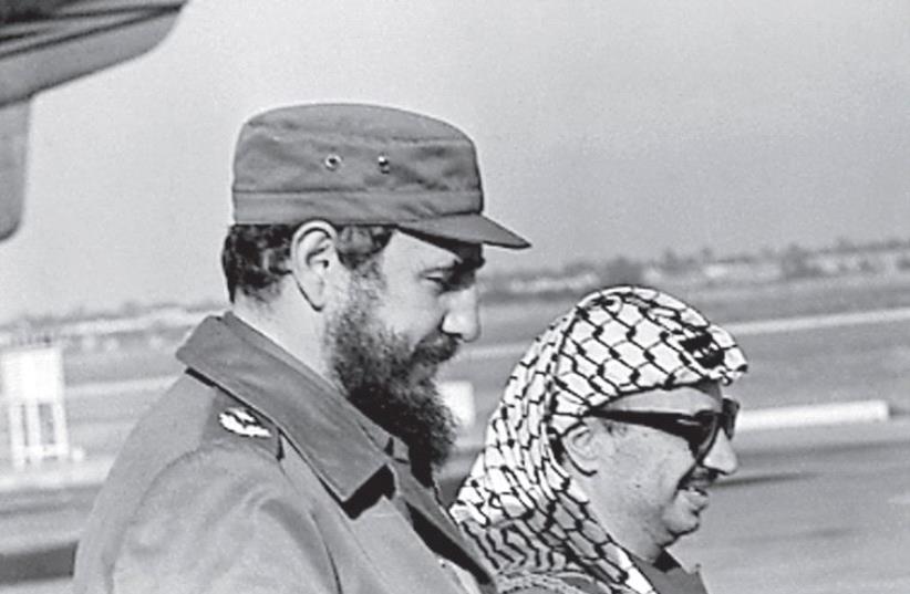 FIDEL CASTRO and Palestinian leader Yasser Arafat stand together at the Havana airport during Arafat’s first visit to Cuba in 1974. (photo credit: REUTERS)