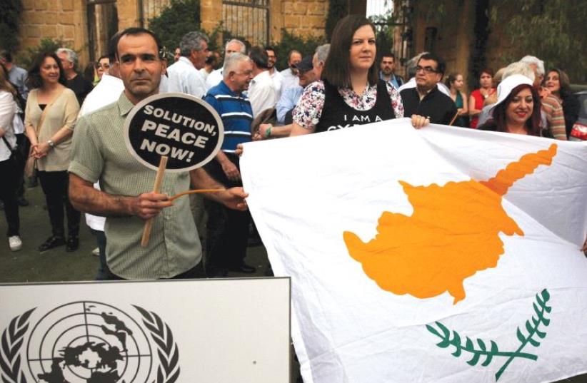 PROTESTORS HOLD a Cyprus flag during a demonstration in favor of a peace settlement on divided Cyprus (photo credit: REUTERS)