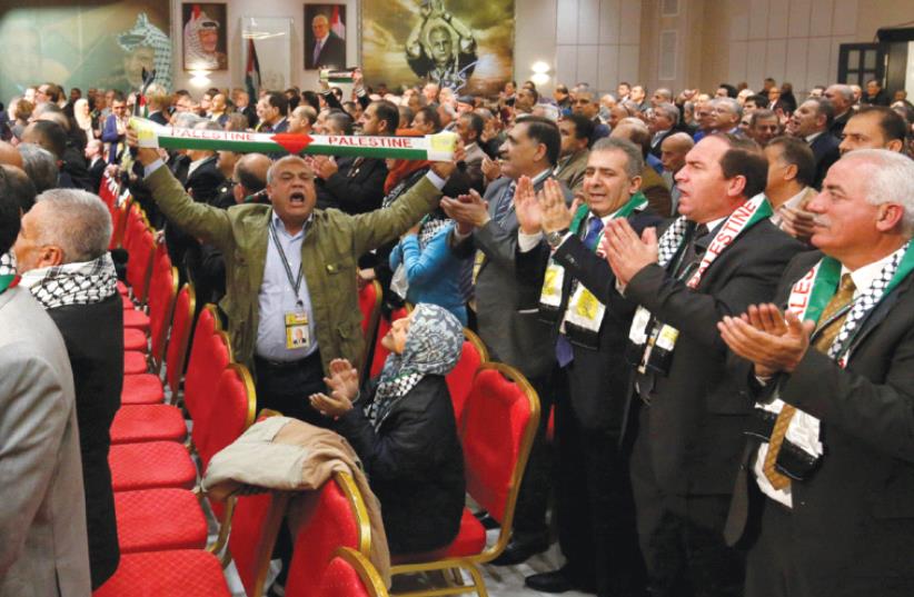 PARTICIPANTS CLAP and cheer before a speech by Palestinian Authority President Mahmoud Abbas during the Fatah Congress in Ramallah (photo credit: MOHAMAD TOROKMAN/REUTERS)