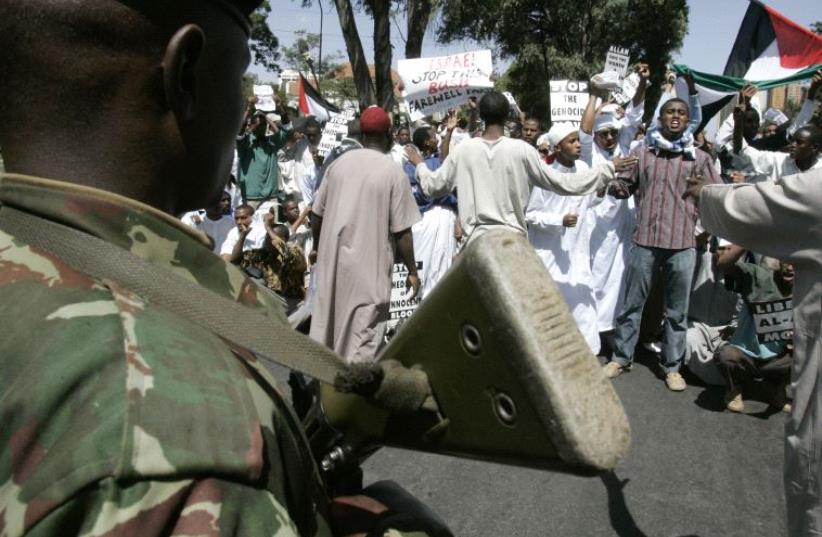 An anti-riot policeman blocks Muslim protesters from marching to the Israeli embassy during a demonstration in Nairobi. (photo credit: REUTERS)