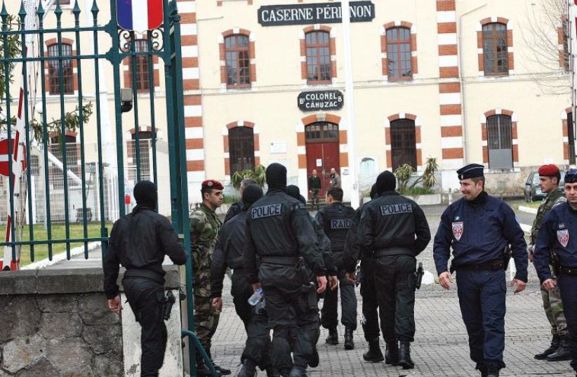 MASKED FRENCH special unit policemen arrive at Perignon barracks after tracking down a terrorist in 2012. (photo credit: REUTERS)