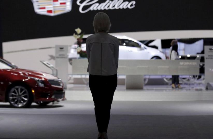 A woman stands in the Cadillac exhibit at the New York International Auto Show media preview in Manhattan, New York March 23, 2016. (photo credit: REUTERS)