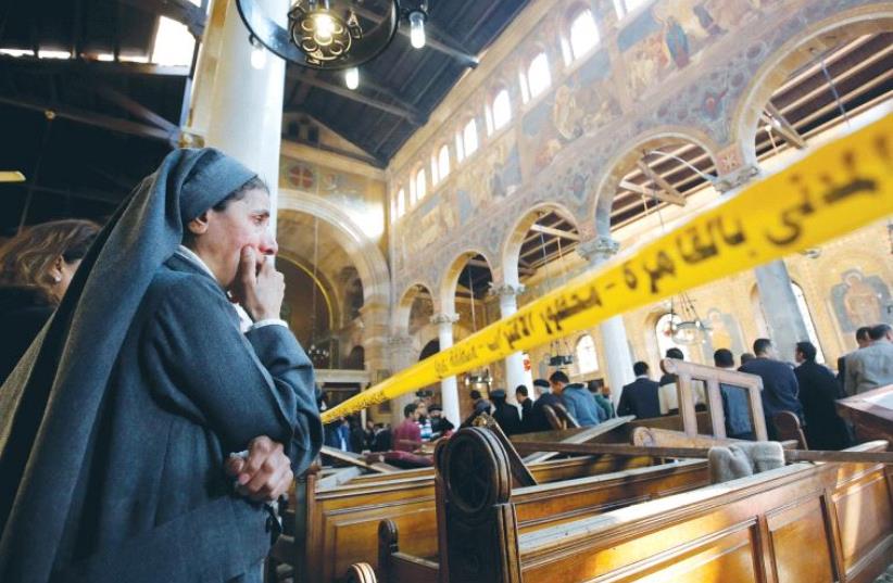 A NUN WEEPS inside Cairo’s St. Marks Coptic Cathedral yesterday, after terrorists killed at least 25 people and wounded 49 during Sunday mass (photo credit: AMR ABDALLAH DALSH / REUTERS)
