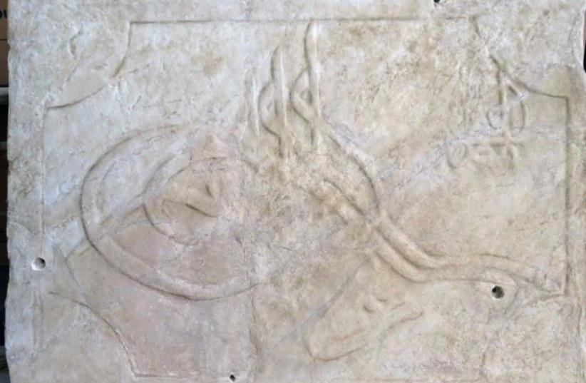 The marble plaque bearing the sultan’s seal prior to conservation; the seal itself cannot be discerned (photo credit: FAINA MILSTEIN/ISRAEL ANTIQUITIES AUTHORITY)