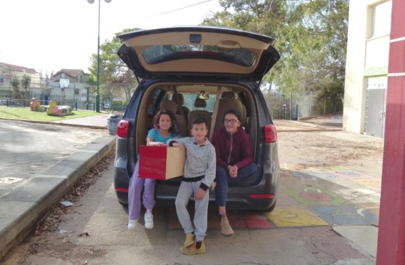 A grateful family loads their car with supplies in Zichron Ya’acov (photo credit: AVI NOWITZ)