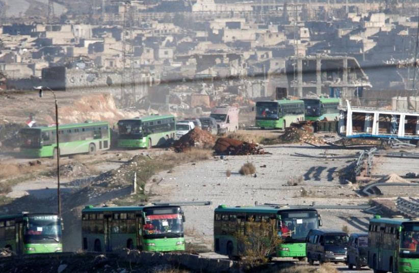Ambulances and buses evacuating people drive out of a rebel-held part of Aleppo, Syria December 15, 2016. (photo credit: REUTERS)
