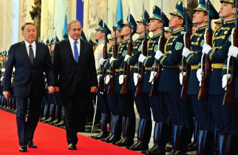 PRIME MINISTER Benjamin Netanyahu walks with Kazakh President Nursultan Nazarbayev at a welcoming ceremony at the Presidential Palace in Astana on Tuesday.  (photo credit: HAIM ZACH/GPO)