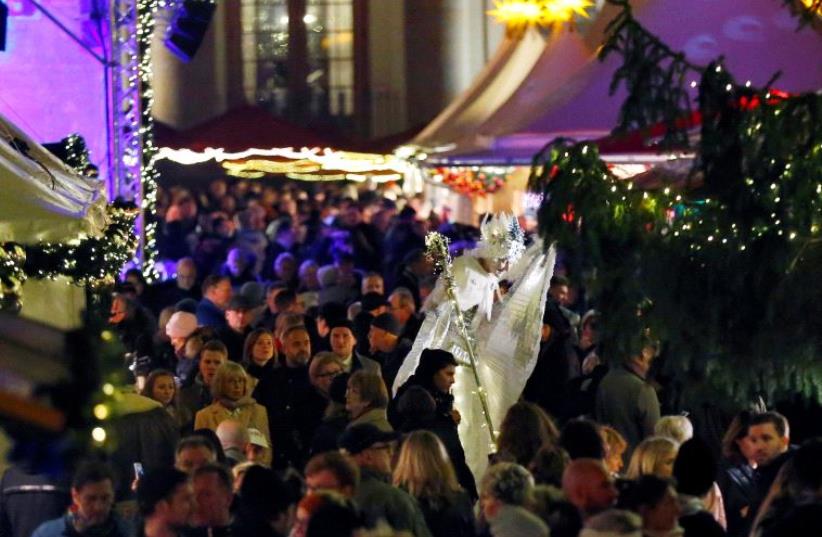 Illustration: people visiting Christmas market in Berlin (photo credit: HANNIBAL HANSCHKE/REUTERS)