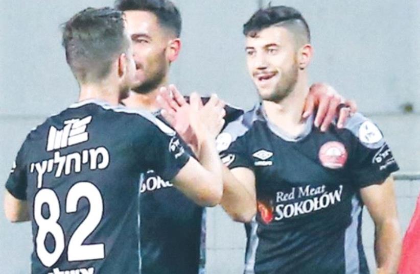 Hapoel Ra’anana midfielder Mohammed Shaker (right) celebrates with teammates after scoring the only goal in last night’s surprise 1-0 victory over Hapoel Beersheba in Netanya. (photo credit: DANNY MARON)