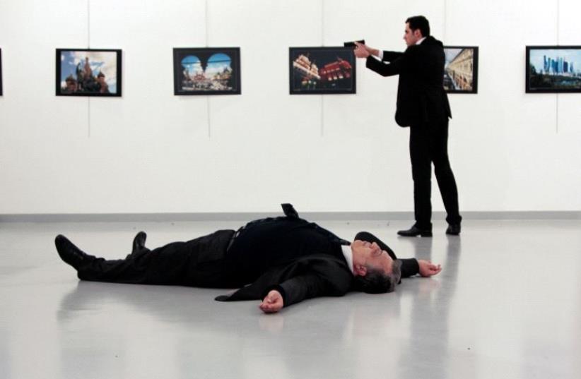 Russian Ambassador to Turkey Andrei Karlov lies on the ground after he was shot by unidentified man at an art gallery in Ankara, Turkey, December 19, 2016. (photo credit: REUTERS)