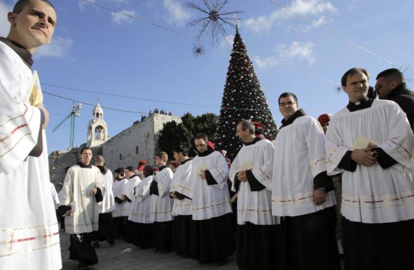 Members of the clergy wait for the arrival of the Latin Patriarch of Jerusalem Fouad Twal during Christmas celebrations in Bethlehem  (photo credit: REUTERS)