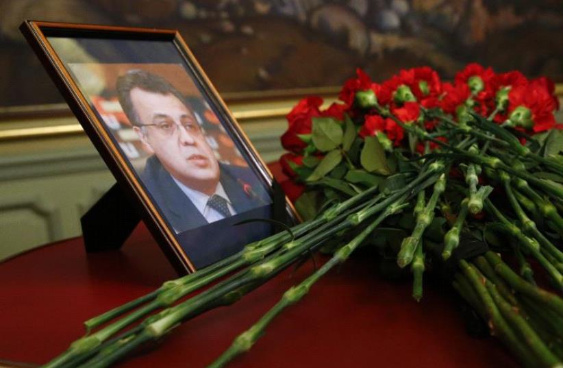 Flowers are placed near a portrait of murdered Russian ambassador to Turkey Andrei Karlov (photo credit: REUTERS)