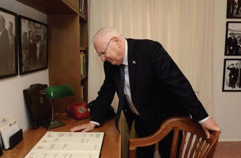 PRESIDENT REUVEN RIVLIN stands alongside prime minister Levi Eshkol’s personal desk and chair. Note the two old-fashioned telephones – the red one being the hot line. (photo credit: MARK NEYMAN / GPO)