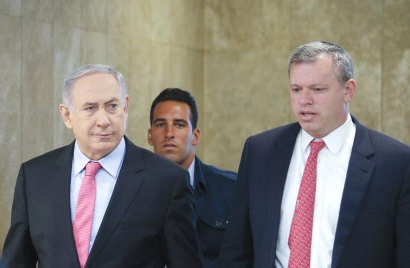 PRIME MINISTER Benjamin Netanyahu is accompanied by PMO Director-General Eli Groner to the weekly government meeting in Jerusalem (photo credit: AMIT SHABI/POOL)
