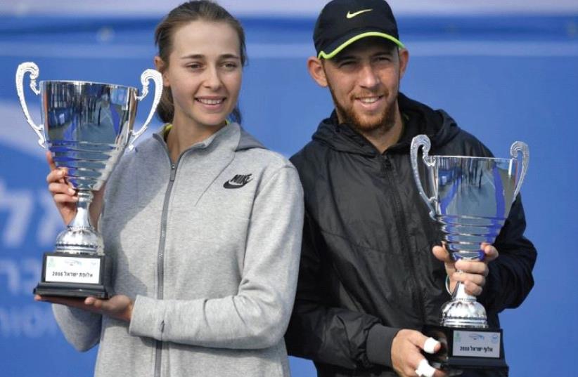 Dudi Sela (right) and Deniz Khazaniuk (left) hold their trophies after claiming their respective Israel national tennis championship titles. (photo credit: ALEX GOLDENSTEIN/ISRAEL TENNIS ASSOCIATION)