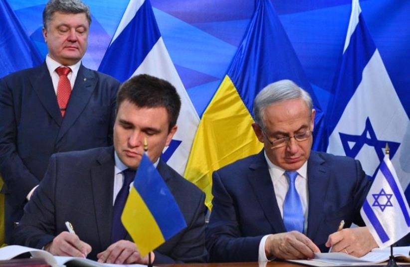 Prime Minister Benjmain Netanyahu and Ukrainian Foreign Minister Pavlo Klimkin sign agreeements as Ukrainian President Petro Poroshenko looks on (photo credit: KOBI GIDEON/GPO)