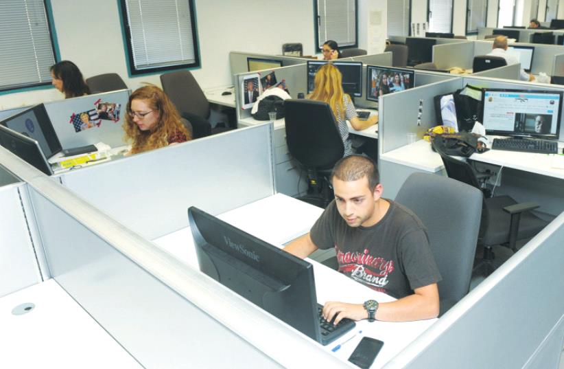 STAFFERS WORK in the offices of the soon-to-debut Israel Broadcasting Corporation in Modi’in. (photo credit: AVSHALOM SASSONI)