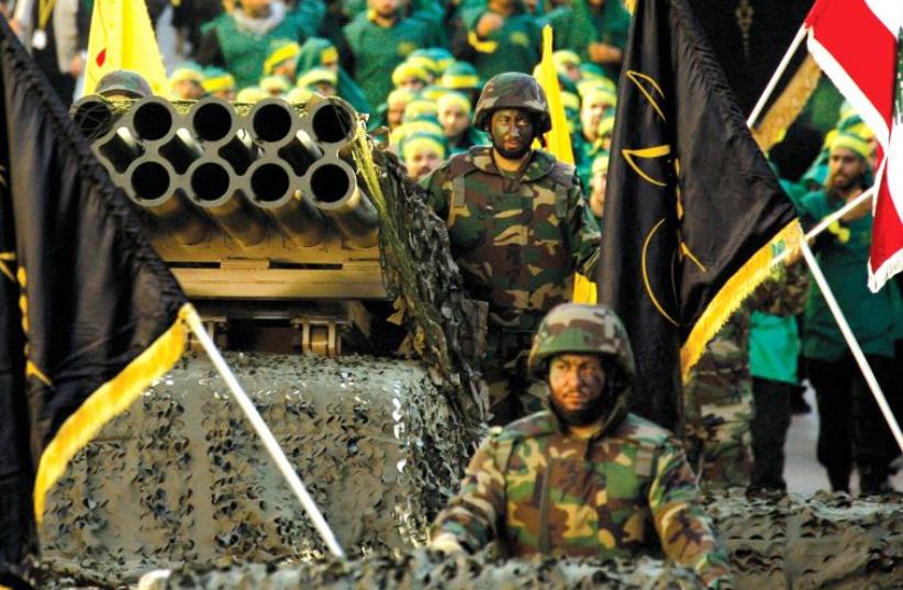 Hezbollah displays a pick-up truck mounted with a multiple rocket launcher in a parade in the southern Lebanese city of Nabatiyeh in 2014 (photo credit: MAHMOUD ZAYYAT / AFP)