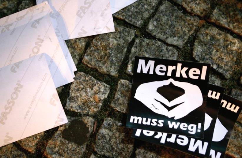 STICKERS WITH the words ‘Merkel must go’ lie on the pavement during a protest in Berlin. (photo credit: REUTERS)