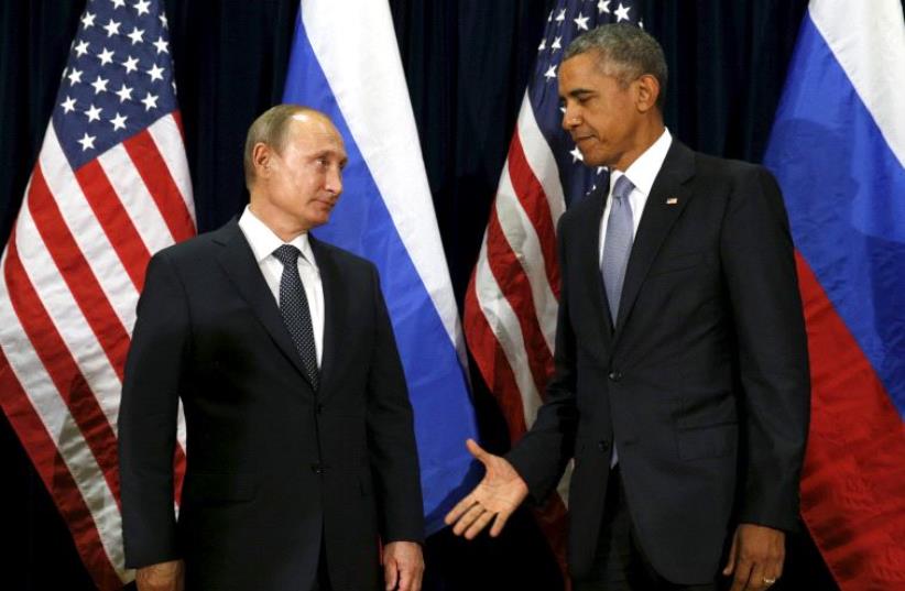 US President Barack Obama extends his hand to Russian President Vladimir Putin during their meeting at the United Nations General Assembly in New York September 28, 2015 (photo credit: REUTERS)