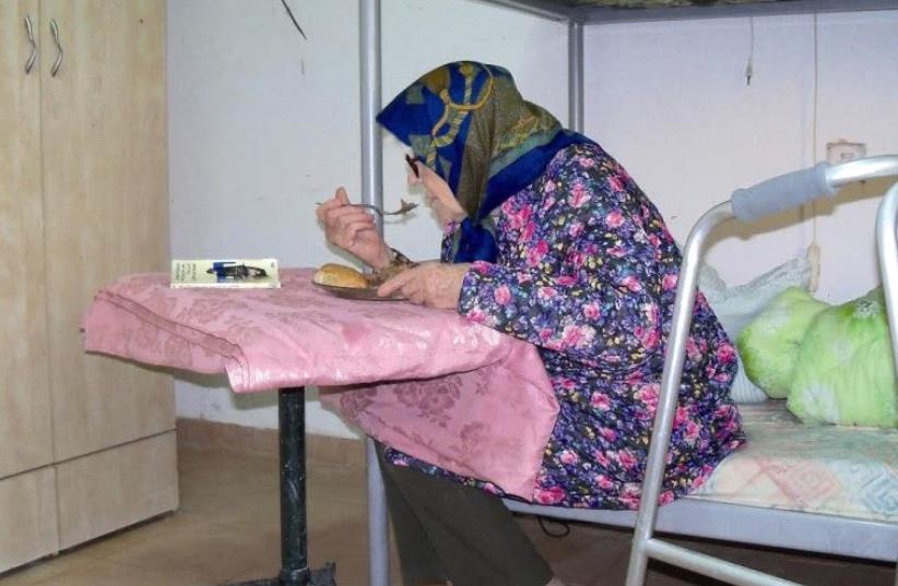 An elderly Holocaust survivor enjoys a warm meal thanks to the Association for Immediate Help for Holocaust Survivors (photo credit: Courtesy)