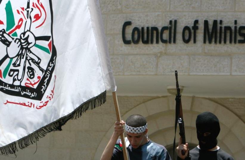 A MEMBER of the Aqsa Martyrs Brigades waves a flag in Ramallah in 2007.  (photo credit: REUTERS)