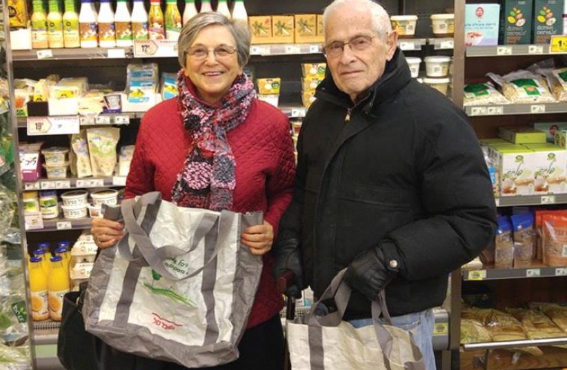 JOAN AND JOE Freudenberger show off their environmentally friendly shopping bags at a Shufersol in Jerusalem on Sunday. (photo credit: DANIEL K. EISENBUD)