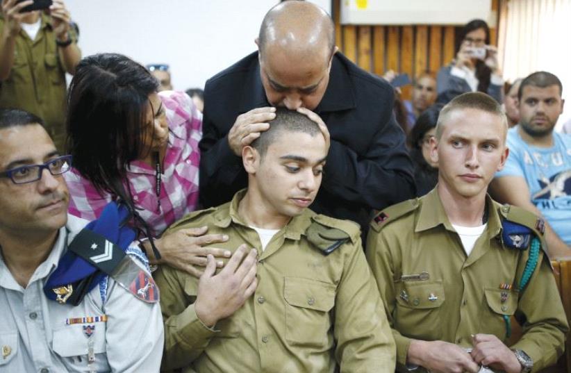 THE FATHER OF IDF soldier Elor Azaria kisses his head during a remand hearing last March (photo credit: REUTERS)