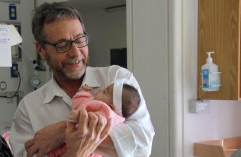 Father holding his baby, who was born with intestines outside body and received a lifesaving procedure at Hadassah University Medical Center in Jerusalem’s Ein Kerem (photo credit: HADASSAH UNIVERSITY MEDICAL CENTER)