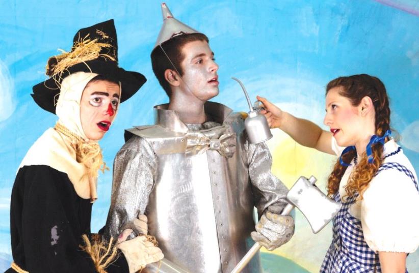 Dorothy oils the rusty Tin Man with the help of the Scarecrow (photo credit: BRIAN NEGIN)