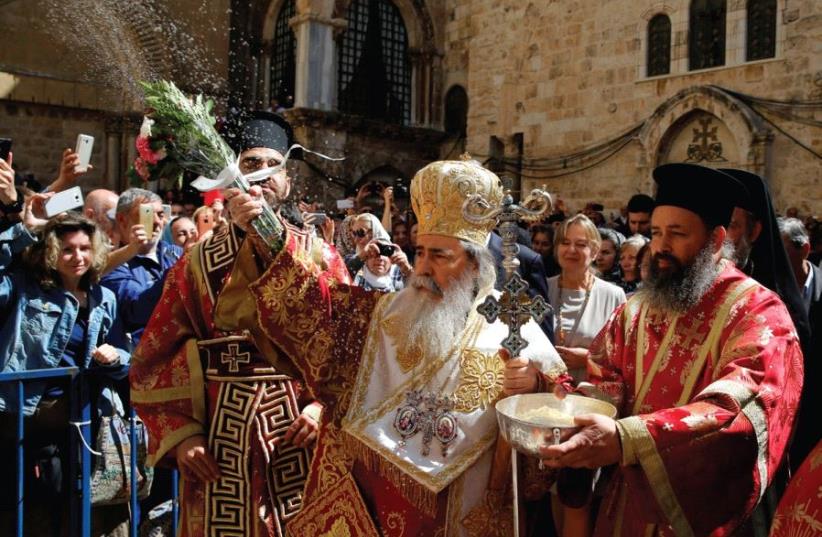 The Greek Orthodox Patriarch of Jerusalem, Metropolitan Theophilos (center), blesses the crowd during the Washing of the Feet ceremony outside the Church of the Holy Sepulcher in Jerusalem’s Old City, April 28, ahead of Orthodox Easter (photo credit: REUTERS)