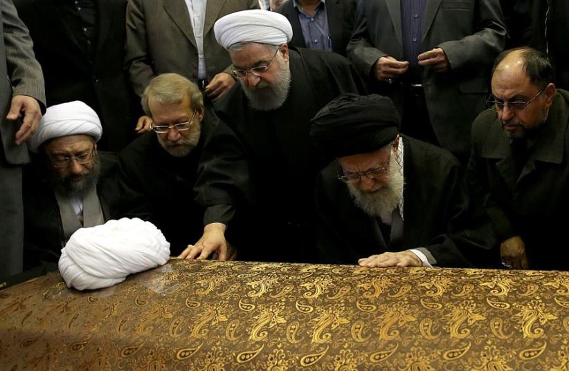 Iran's Supreme Leader Ayatollah Ali Khamenei and Iran's President Hassan Rouhani touch the coffin of former president Ali Akbar Hashemi Rafsanjani. (photo credit: REUTERS)