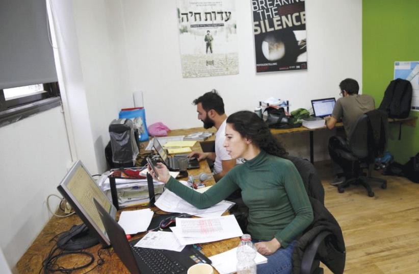 EMPLOYEES WORK at the offices of the Breaking the Silence NGO in Tel Aviv in 2015 (photo credit: REUTERS)