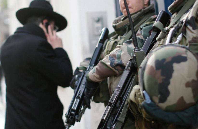 FRENCH SOLDIERS patrol the street in a Jewish neighborhood following a string of terrorist attacks in Paris in 2015. (photo credit: REUTERS)