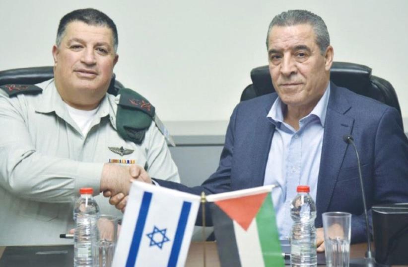 MAJ.-GEN. YOAV (POLY) MORDECHAI (left) shakes hands with Palestinian Authority Civil Affairs Minister Hussein al-Sheikh after agreeing to renew activities of the Joint Water Committee. (photo credit: COGAT)