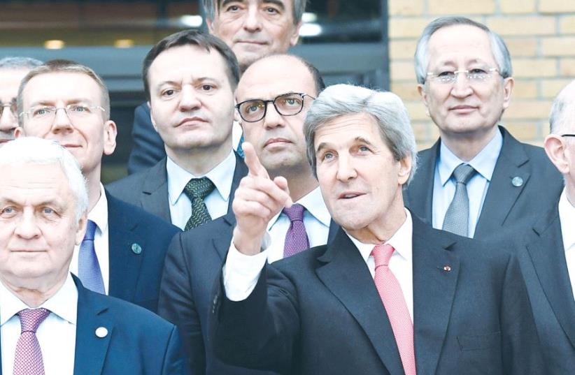 John Kerry standing among foreign ministers at Paris peace conference (photo credit: REUTERS)