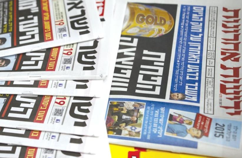 COPIES OF ‘Israel Hayom’ and ‘Yediot Aharonot’ are displayed in Ashkelon l (photo credit: REUTERS)