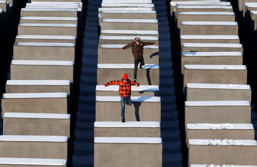 People jump from concrete elements of the Holocaust memorial in Berlin (photo credit: REUTERS)