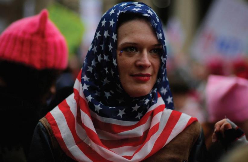 A WOMAN wears a US flag scarf during the Women’s March on Washington, DC, following the inauguration of Donald Trump (photo credit: REUTERS)
