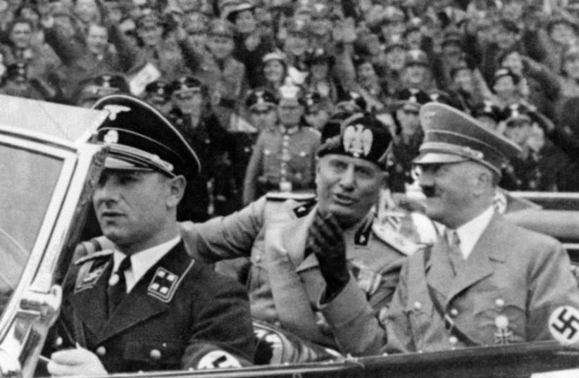 A picture taken in September 1937, in Munich, shows German Chancellor Adolf Hitler (R) riding in a car with Italian dictator Benito Mussolini while the crowd gives the fascist salute. (photo credit: SNEP / AFP)